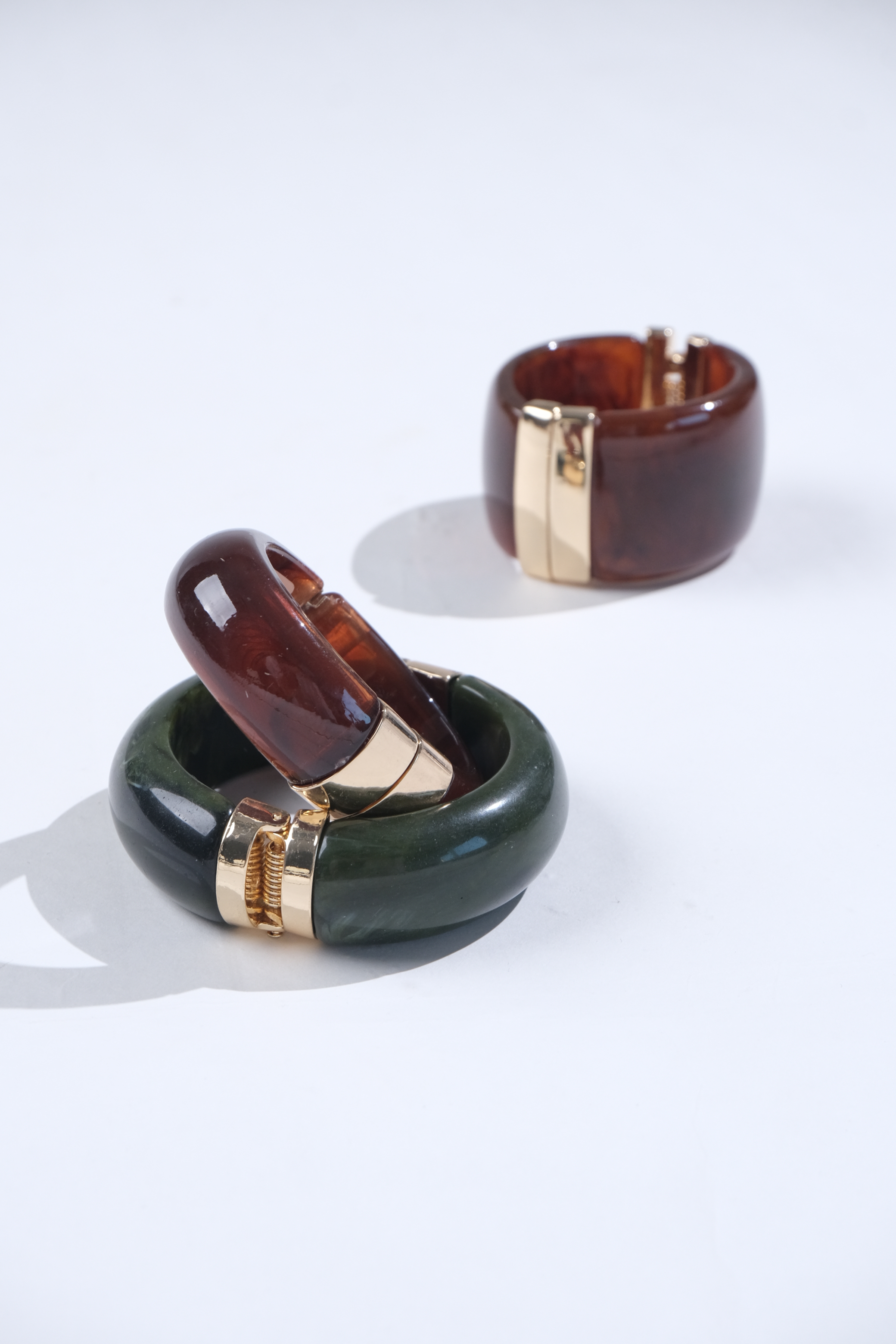 Brown and green bracelets with gold-tone details
